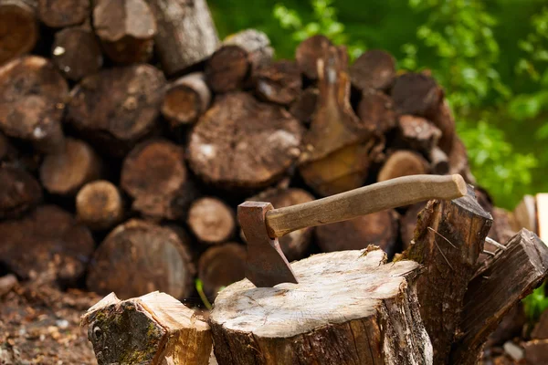 Old ax on log and firewood in the background — Stock Photo, Image