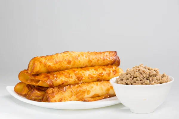 Pannenkoeken met vlees op wit bord — Stockfoto