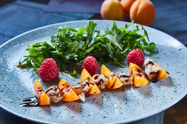 De organische salade met rucola, framboos, abrikoos en kaas. — Stockfoto