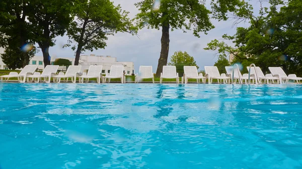 Wimming pool med blått vatten och Tom solsäng — Stockfoto