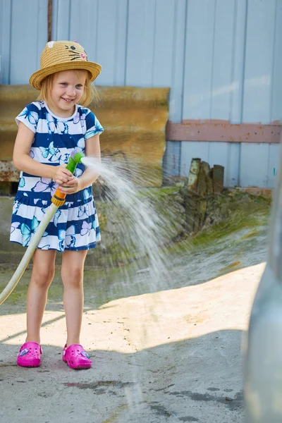 小さな幸せな女の子水まき庭 — ストック写真