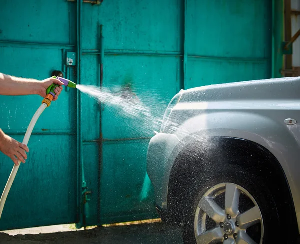 Gente limpiando coche usando agua de alta presión — Foto de Stock