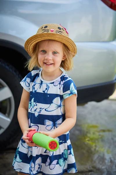 Leuk meisje spelen met water gun automatische waterpistool — Stockfoto