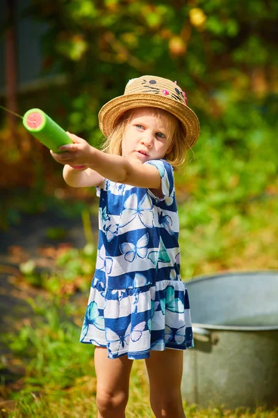 Pěkná dívka si hraje s vodní pistole — Stock fotografie