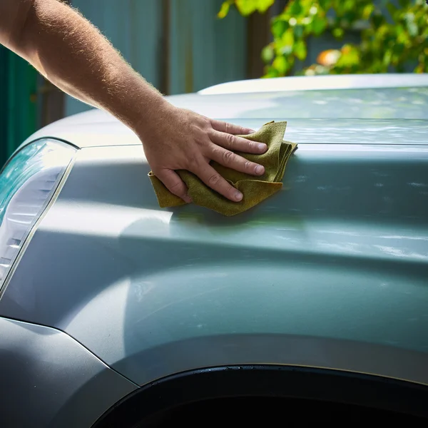 Zbliżenie z ręki z zielona pędzla mycie samochodu — Zdjęcie stockowe