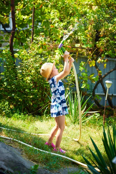 快乐的女孩浇水的小花园 — 图库照片