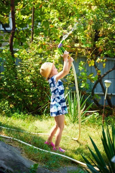 小さな幸せな女の子水まき庭 — ストック写真