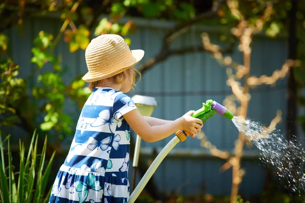 Malá šťastná dívka zavlažování zahrady — Stock fotografie