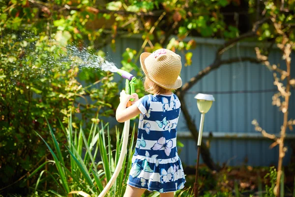 Malá šťastná dívka zavlažování zahrady — Stock fotografie