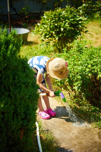 Pequena menina feliz rega jardim — Fotografia de Stock