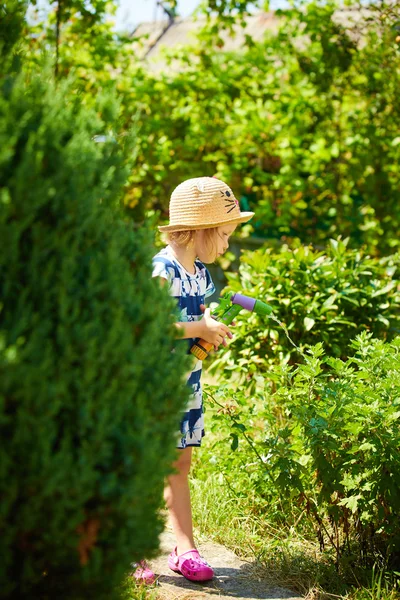 Piccola ragazza felice irrigazione giardino — Foto Stock