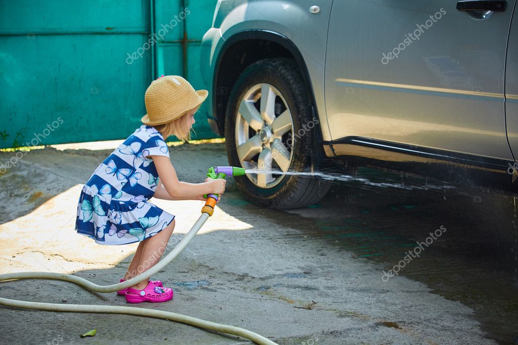 Kleines Mädchen hilft ihren Eltern, das Auto zu waschen.