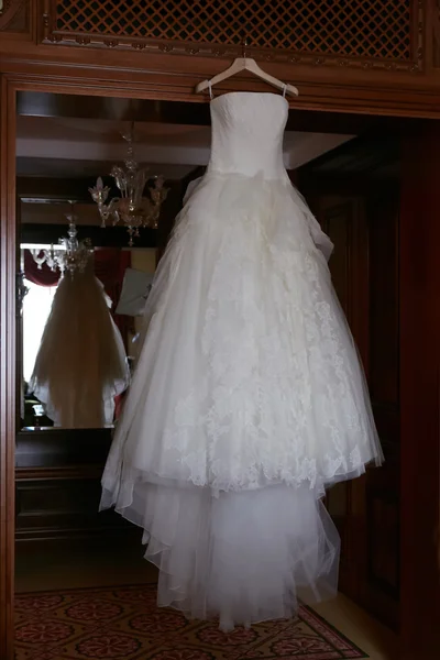 Белое свадебное платье висит на плечах — стоковое фото