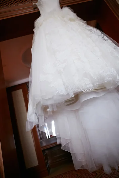 Vestido de casamento branco pendurado em um ombro — Fotografia de Stock