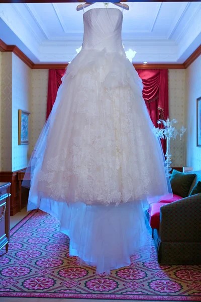 Белое свадебное платье висит на плечах — стоковое фото