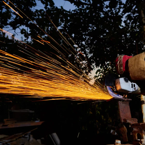 Trabalhador de corte de metal com moedor. Faíscas enquanto moagem de ferro — Fotografia de Stock