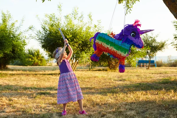 Mladá dívka na venkovní party bít pinata — Stock fotografie