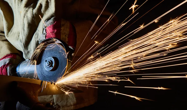 Travailleur de coupe de métal avec broyeur. Étincelles pendant le broyage du fer — Photo