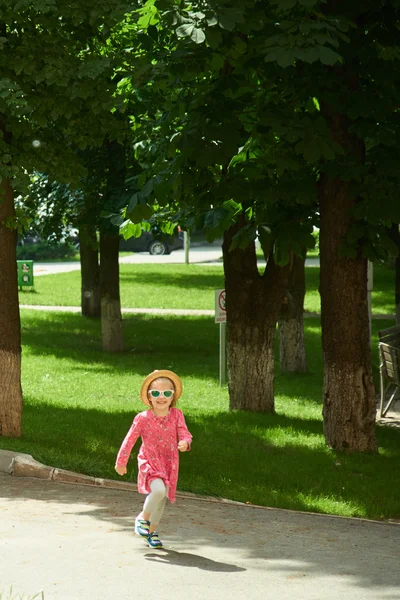 Glückliches süßes kleines Mädchen, das im Park läuft. Glück. — Stockfoto