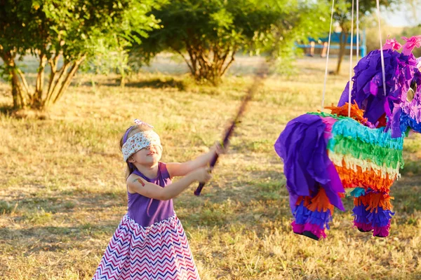 Mladá dívka na venkovní party bít pinata — Stock fotografie