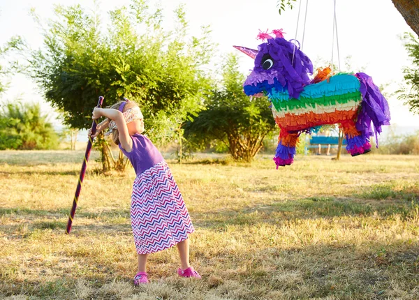 Chica joven en una fiesta al aire libre golpeando una piñata —  Fotos de Stock