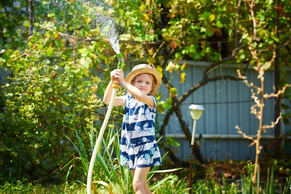 Liten glad tjej vattning trädgård — Stockfoto