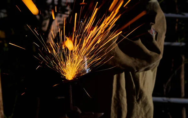 Trabajador de corte de metal con amoladora. Chispas mientras moliendo hierro — Foto de Stock