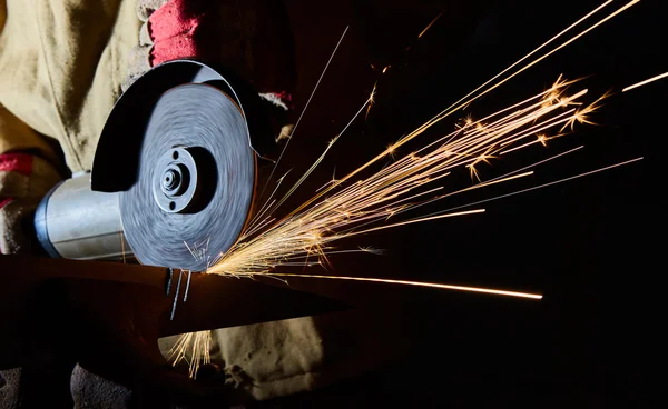 Werknemer die metaal snijdt met slijpmachine. Vonken tijdens het slijpen ijzer — Stockfoto