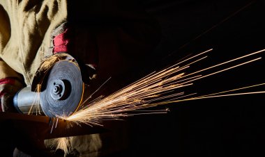 Worker cutting metal with grinder. Sparks while grinding iron clipart