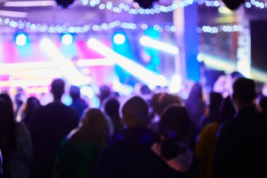 Müzik konseri arka plan bulanıklığı. Arka planda orijinal bokeh ışıkları olan bulanık insanlar - disko kulübünün sanatsal bir dokunuşu için odaklanmış görüntü - gece hayatı kavramı müzik ve eğlence ile