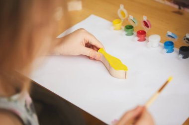 Çocuk boyama. Anaokulundaki mutlu kız elinde fırça boyasıyla resim yapıyor. Evde çocuklarla projeni kendin yap. Sığ dof