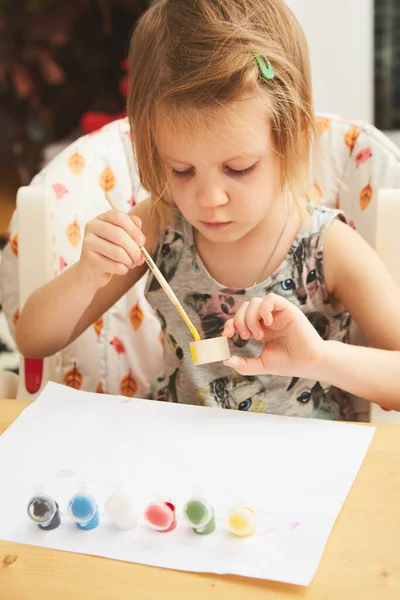 Peinture d'enfant. Bonne fille d'âge préscolaire tenant une peinture au pinceau avec de la peinture. Faites-le vous-même projet avec les enfants à la maison. Dof peu profond — Photo