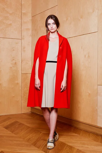 Junges schlankes Model trägt roten Mantel im Studio — Stockfoto