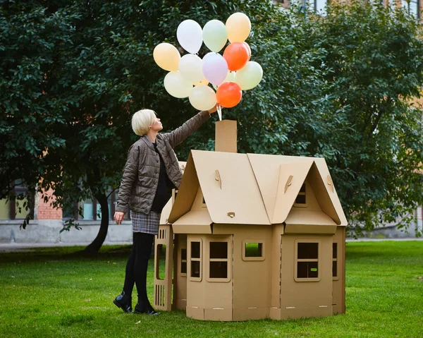 Happy educator playing with girl in playhouse in kindergarten — Stock Photo, Image