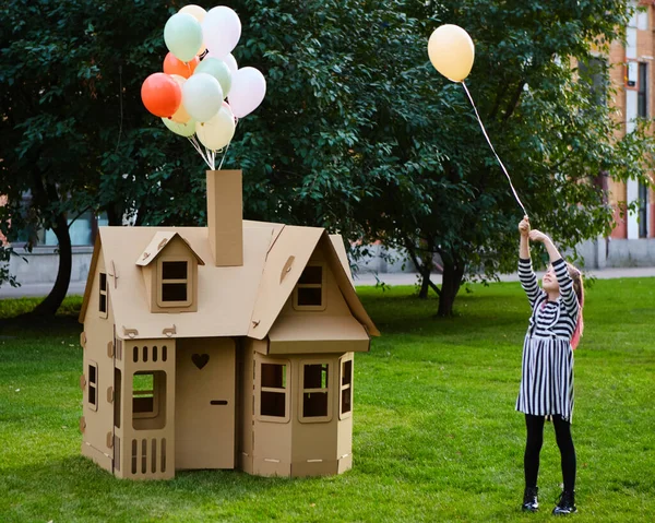 Criança brincando em um playhouse de papelão. Conceito ecológico — Fotografia de Stock