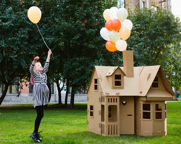 Criança brincando em um playhouse de papelão. Conceito ecológico — Fotografia de Stock