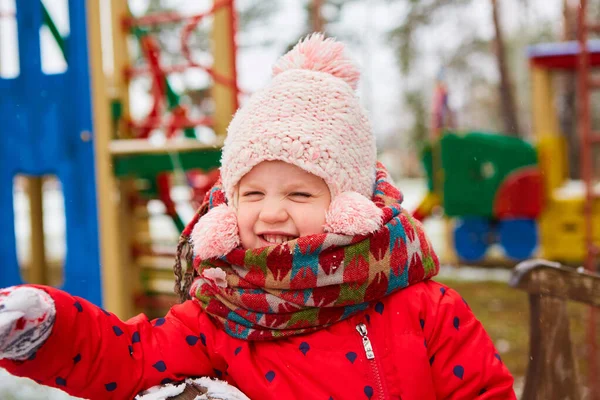 Lekfull flicka har roligt vintertid i en snöpark. Söt lekfull flicka utomhus njuter av första snön. — Stockfoto