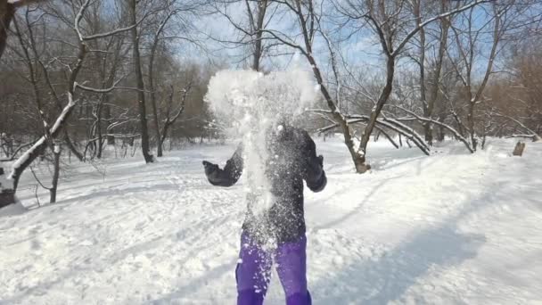 Tânărul barbă de etnie caucaziană în haine calde aruncă o grămadă de zăpadă și zâmbește frumos. Odihnă activă în parc în sezonul de iarnă. Conceptul de timp distractiv. Slow motion . — Videoclip de stoc