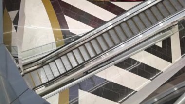 Alışveriş merkezindeki boş yürüyen merdiven. Alışveriş merkezindeki yürüyen merdivende yukarı metal basamaklar. Camdan kenarları ve metal basamakları olan bir alışveriş merkezi. 4K