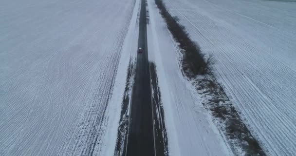 끝없는 아스팔트의 겨울 여행. 고속 도로에서 혼자 운전하는 차가 있어요. 공중 드론 영상 — 비디오