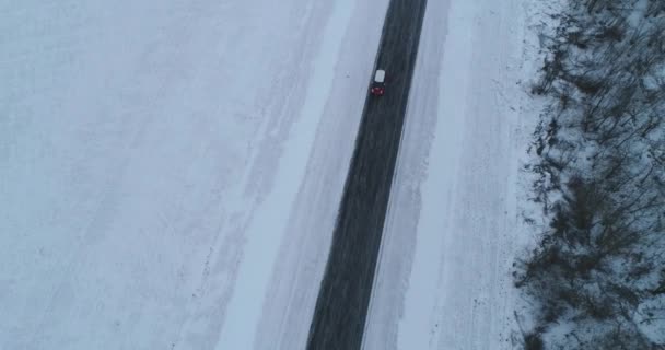 Sonsuz asfalt yolu kış gezisi. Tek başına otoyolda tek başına giden bir araba. Hava aracı görüntüleri.. — Stok video