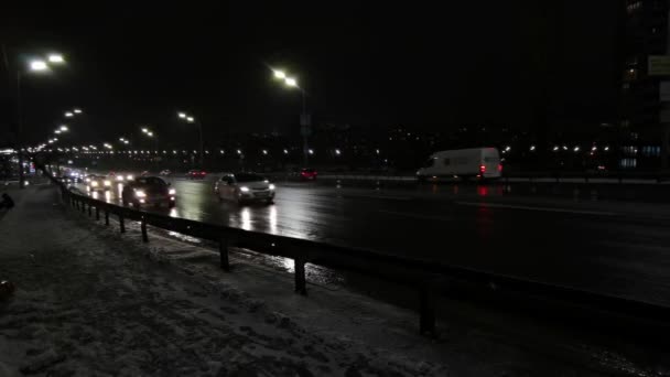 Nierozpoznawalny ruch samochodowy w mieście w zimową śnieżną noc — Wideo stockowe