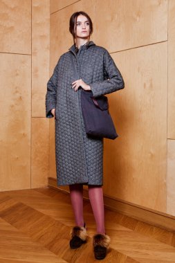 Havalı aksesuarlar takan güzel, şık bir kadının kapalı mekândaki portresi. Kadın modası, güzellik ve reklam konsepti. Metin için alanı kopyala.