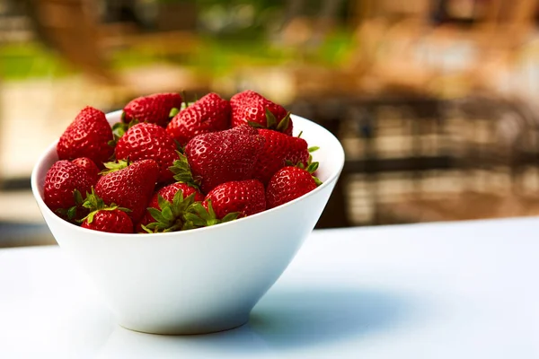Schüssel mit frischen Erdbeeren auf dem Tisch im Garten — Stockfoto