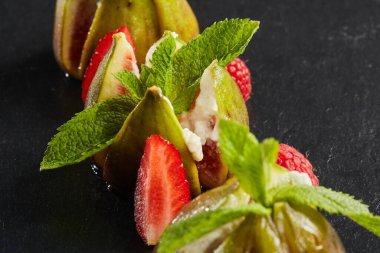 Peynirli incirler nane yaprağı, ahududu ve çilekle süslenmiş. Akdeniz mutfağı. Sığ dof.