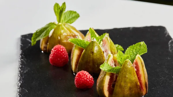 Os figos com queijo decorado com folhas de hortelã e framboesas e morangos. Cozinha mediterrânea. Dof rasa. — Fotografia de Stock