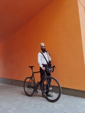 Bisikletinin yanında poz veren şık bir hippi..