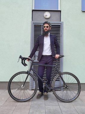 İşe giderken bisiklet süren genç ve şık bir işadamı..