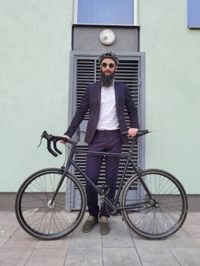İşe giderken bisiklet süren genç ve şık bir işadamı..