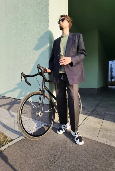 Millennial s bicykl pít kávu venku — Stock fotografie